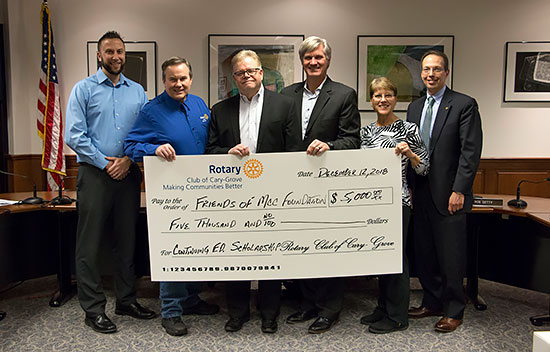 photo of check being received by Justin DeBolt, Dori Sullens and Friends of MCC Board members
