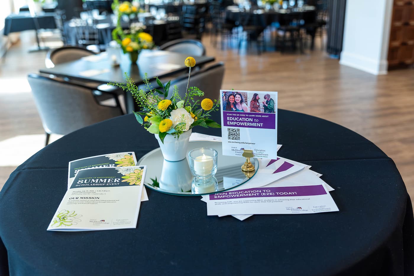 a table at the E2E event with programs and flowers