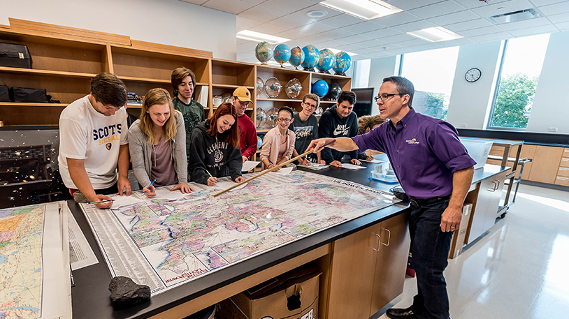 Ted Erski showing students a map