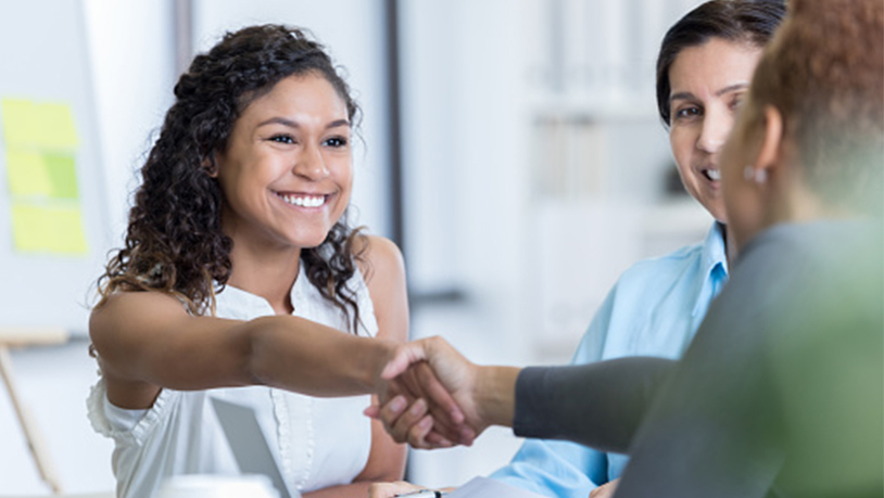 photo of smiling girl handshaking in job interview