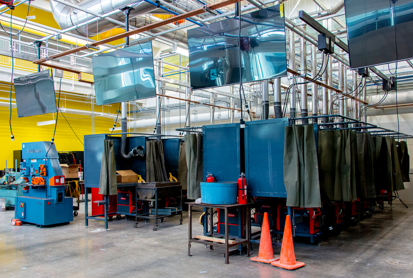 several welding booths built out of blue metal in MCC's Foglia CATI