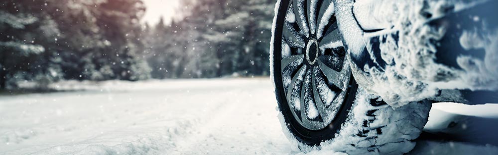 Winter scene with a car tire on a snowy road