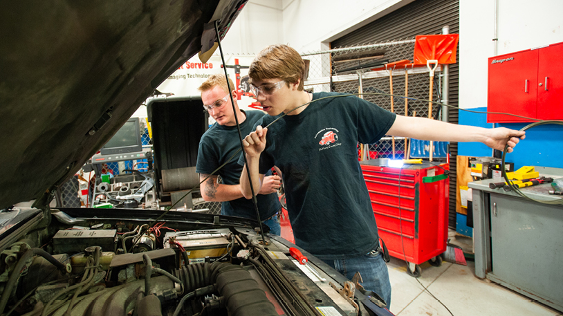 automotive students working under hood of car
