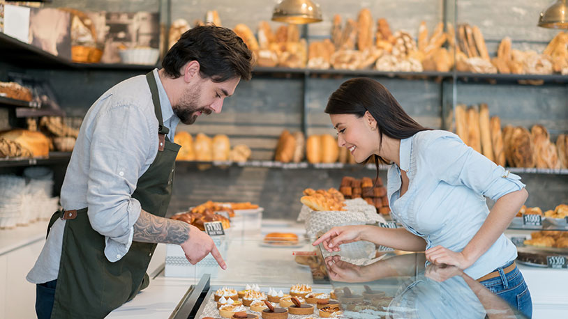 baker helping customer with pastries