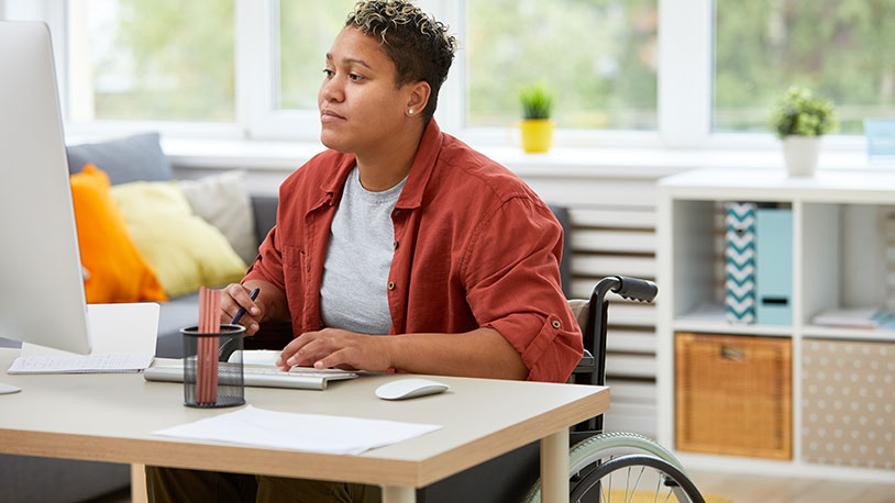 woman in wheel chair working in office