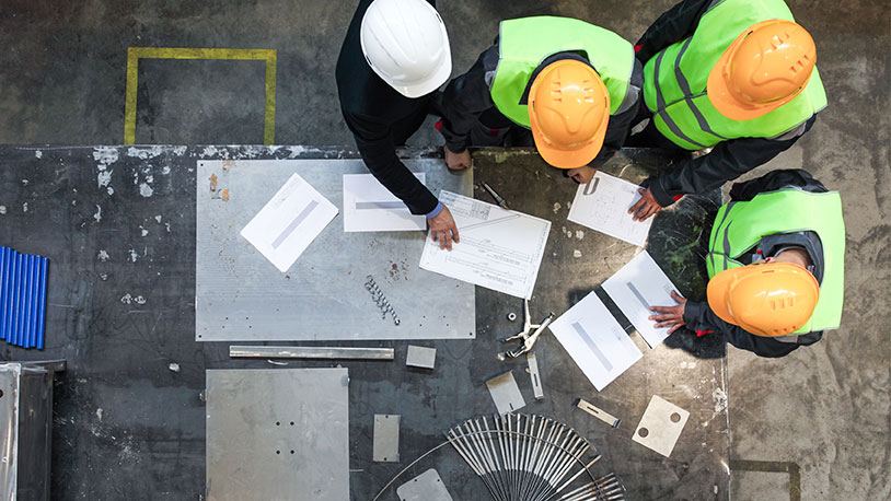 construction workers looking over blueprints