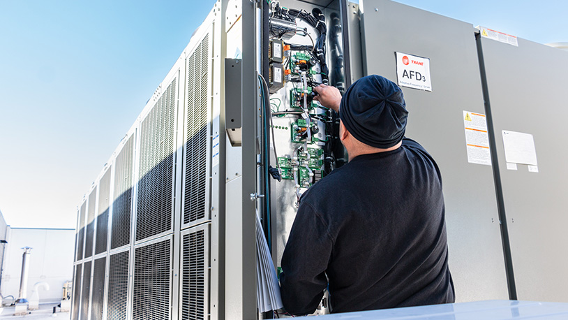 A technician works on a roof-top chiller.