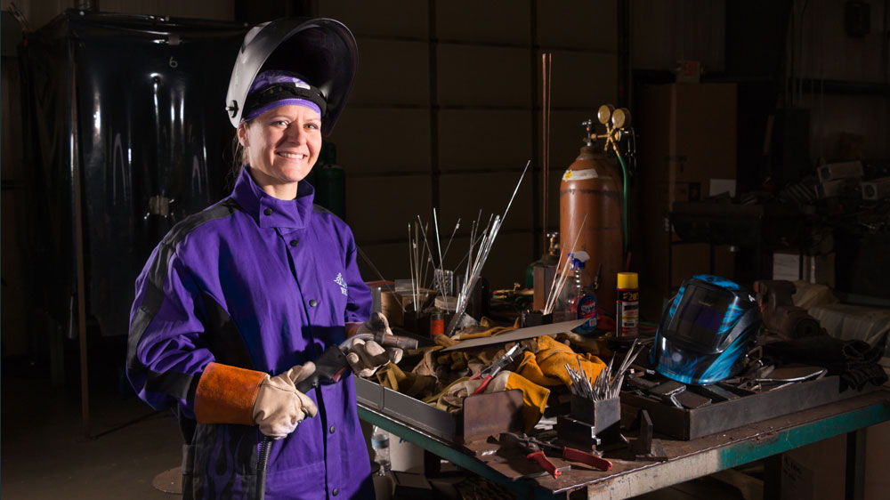 Welding student in class wearing welding helmet