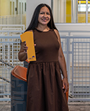 MCC student Martha Malvaez stands in the CATI holding a number 1. 