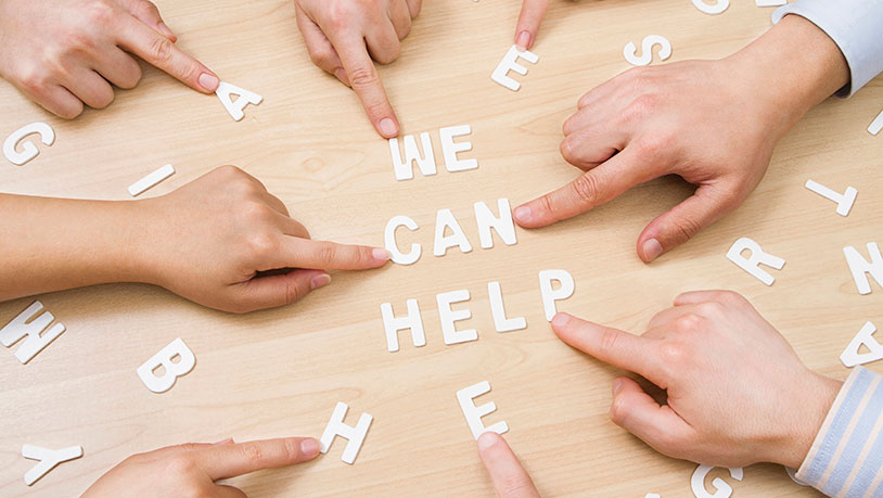 Hands on a table with the words "We can help."